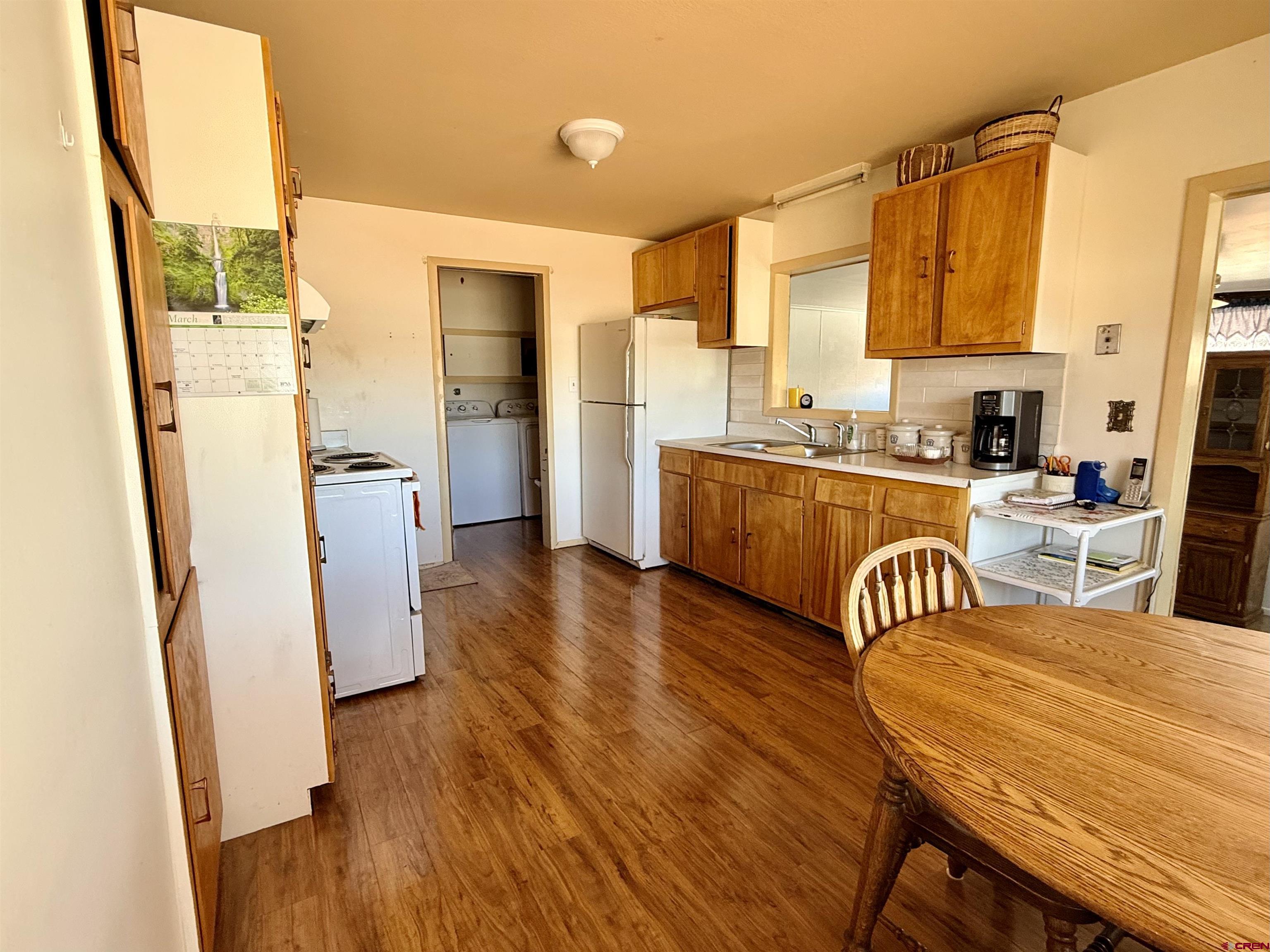 631 A Street Delta, CO 81416 - Photo 8 of 25 a kitchen with stainless steel appliances a dining table chairs sink and wooden floor