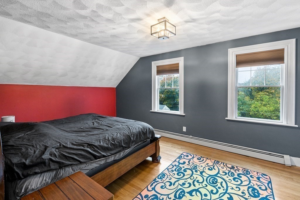 868 Main Street Reading, MA 01867 - Photo 17 of 32 a bed sitting in a bedroom next to a window