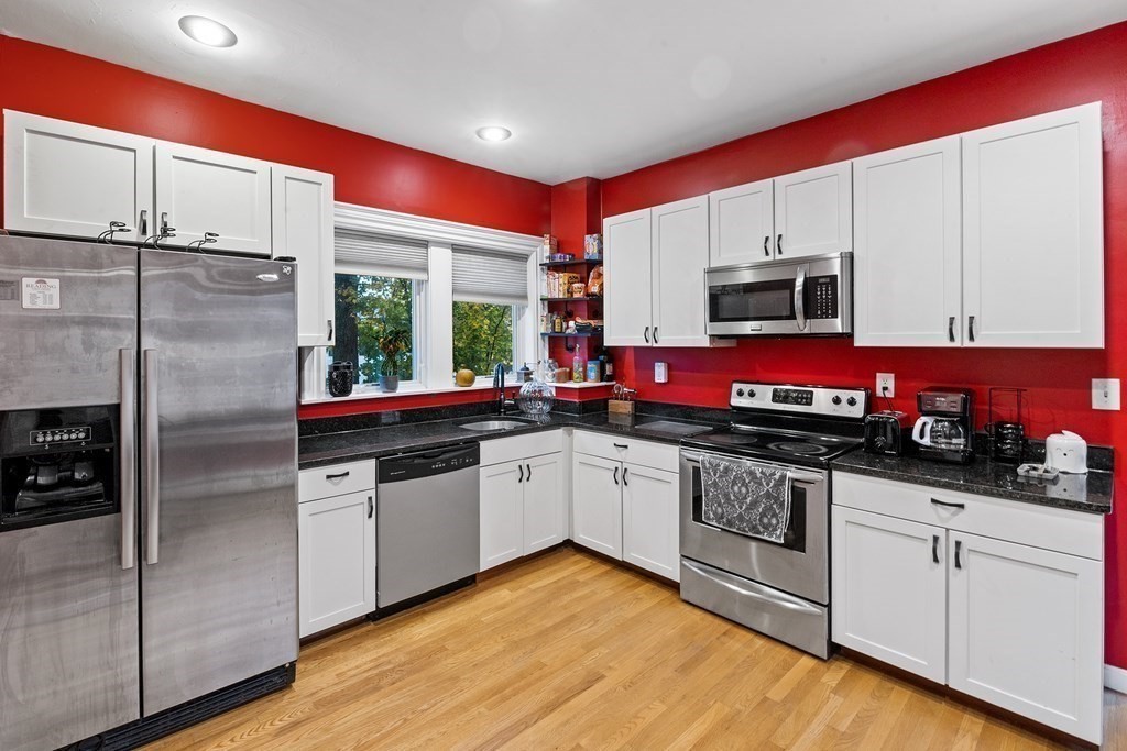 868 Main Street Reading, MA 01867 - Photo 7 of 32 a kitchen with stainless steel appliances kitchen island granite countertop a sink and cabinets