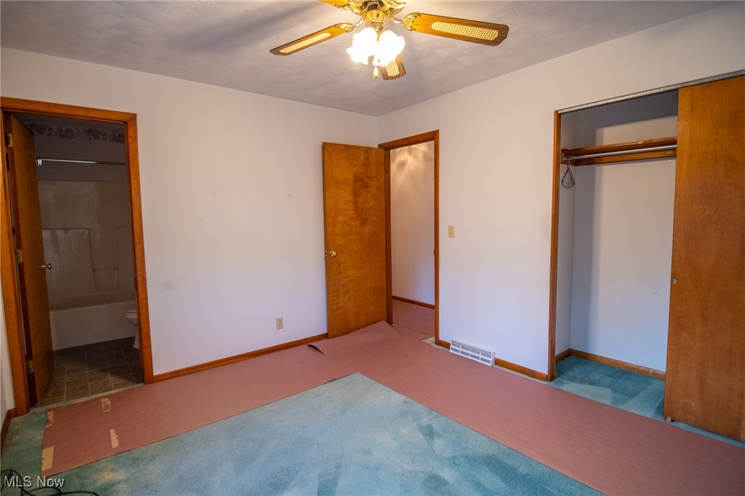 54346 Bracken Road Bridgeport, OH 43912 - Photo 27 of 50 Unfurnished bedroom with ceiling fan, connected bathroom, a closet, and carpet