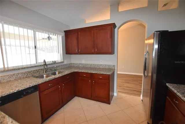 a kitchen with stainless steel appliances granite countertop a refrigerator and a sink