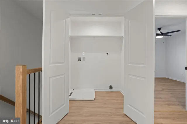 a view of a hallway with wooden floor and closet