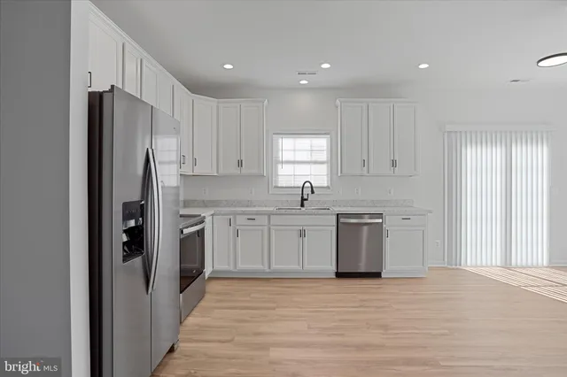 a kitchen with a refrigerator sink and cabinets