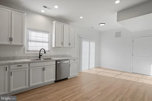 a kitchen with a sink cabinets and wooden floor