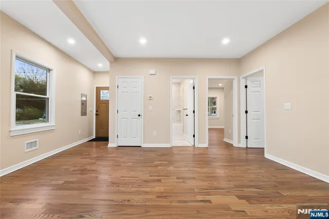 a view of empty room with wooden floor and windows