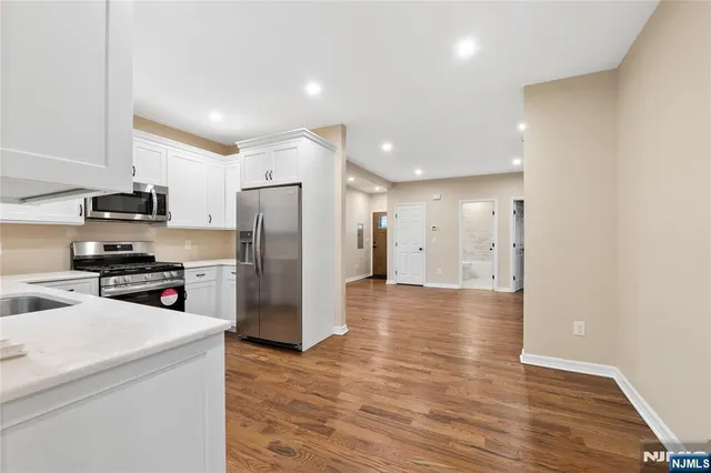 a kitchen with stainless steel appliances a refrigerator and a stove top oven