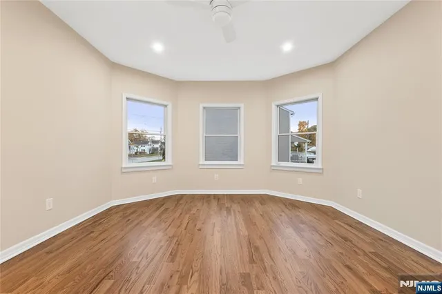 a big room with wooden floor and windows