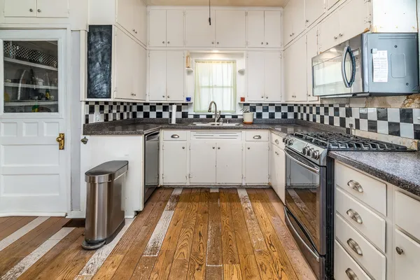 a kitchen with granite countertop a sink stainless steel appliances and cabinets