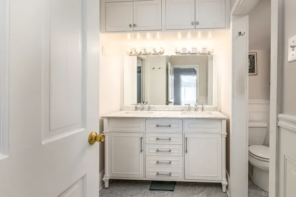 a bathroom with a sink a toilet and a mirror