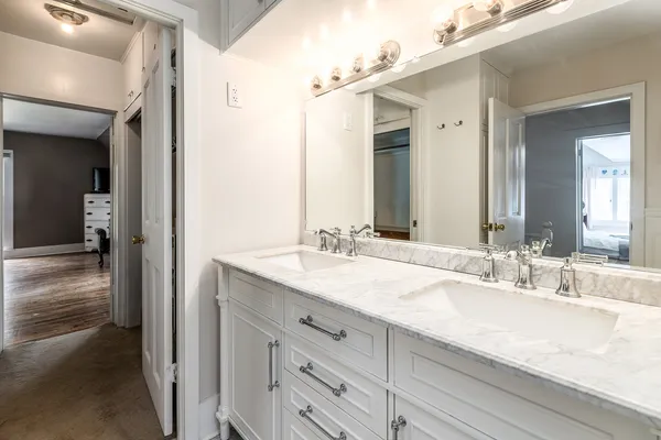 a bathroom with double vanity sinks and a mirror
