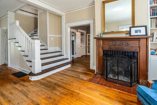 a view of a livingroom with wooden floor and a fireplace
