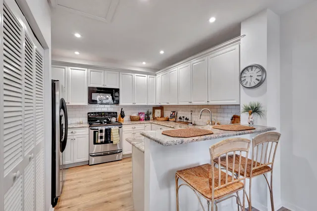a living room with furniture kitchen view and a chandelier