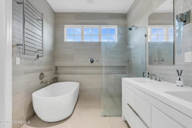 a bathroom with a sink mirror and a bathtub