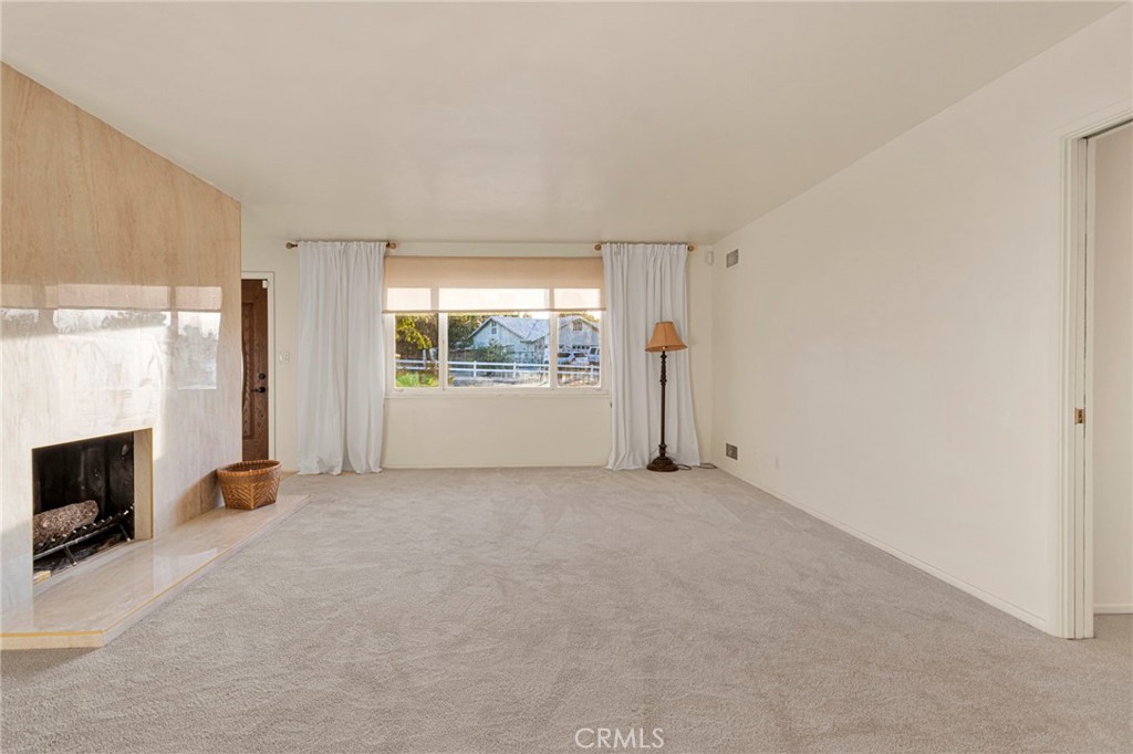 15177 Mendota Road North Apple Valley, CA 92307 - Photo 5 of 50 an empty room with fireplace and windows