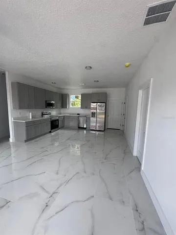 a living room with furniture and a refrigerator