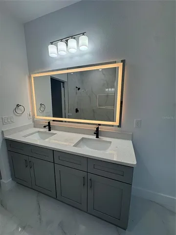 a bathroom with a double vanity sink and a mirror