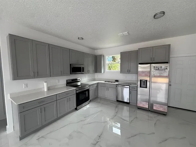 a kitchen with granite countertop a sink stainless steel appliances and cabinets