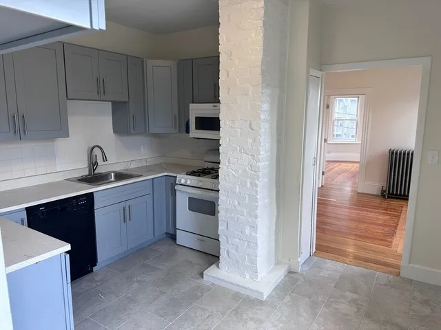 a kitchen with cabinets appliances and a window