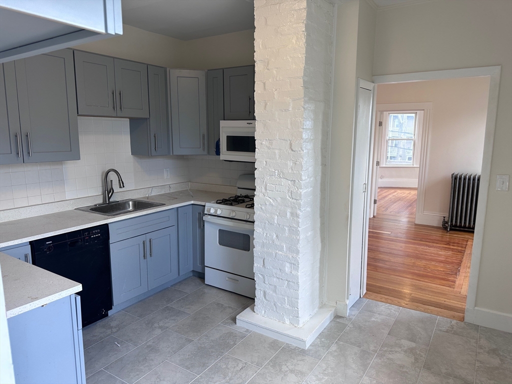 a kitchen with cabinets appliances and a window
