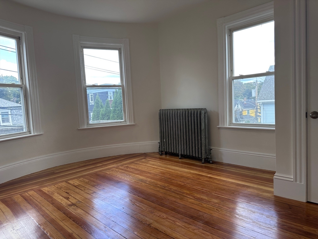 27 Bailey Street, Unit 2 Boston, MA 02124 - Photo 4 of 12 an empty room with wooden floor and windows