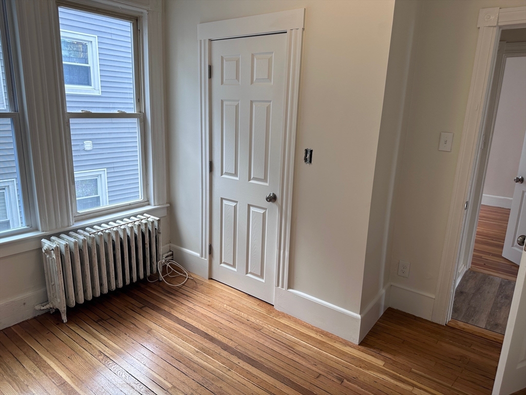 27 Bailey Street, Unit 2 Boston, MA 02124 - Photo 8 of 12 an empty room with wooden floor and windows