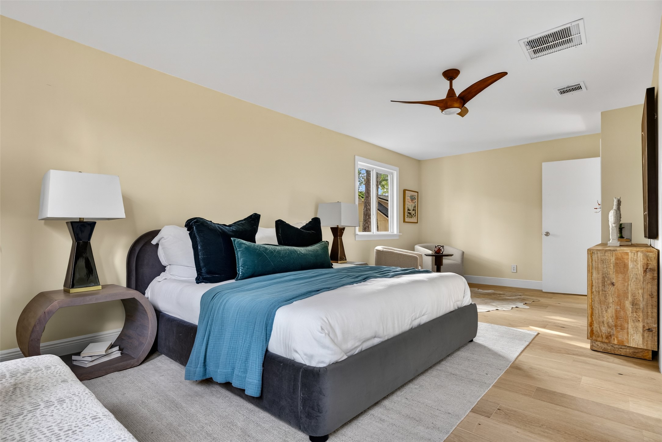 6806 Rearden Road Austin, TX 78745 - Photo 10 of 28 Spacious room featuring light wood-finish flooring, a modern ceiling fan, and a large window providing natural light
