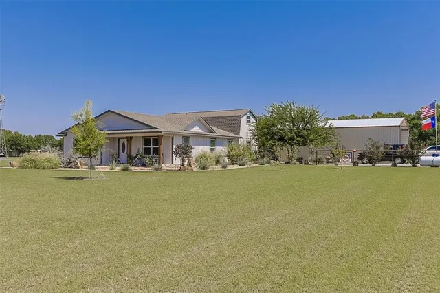 a front view of house with yard and ocean view