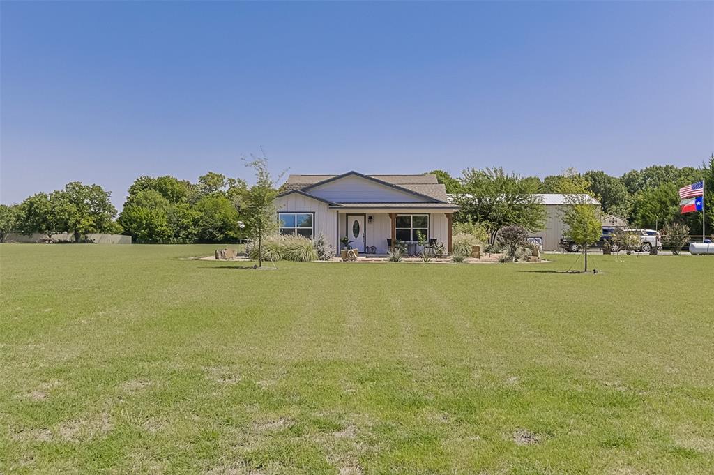 2683 Bells Chapel Road Palmer, TX 75152 - Photo 21 of 28 a front view of a house with a garden and a lake view