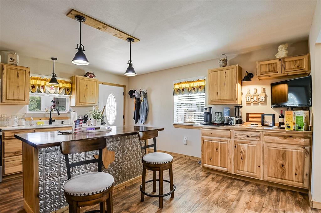 2683 Bells Chapel Road Palmer, TX 75152 - Photo 8 of 28 a kitchen with a dining table chairs sink and wooden floor