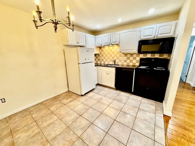 a kitchen with a sink a refrigerator and cabinets