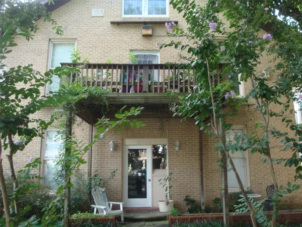 aerial view of a house with balcony and trees