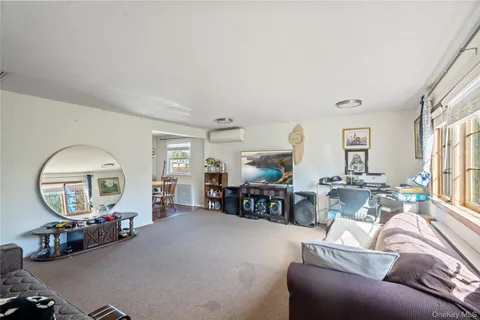 a living room with furniture a mirror and a large window
