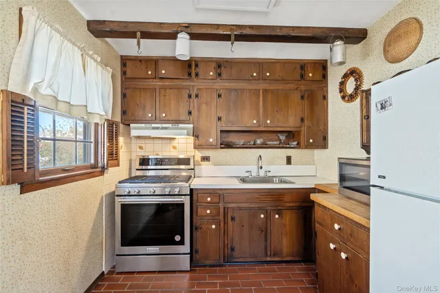 a kitchen with a sink stove top oven and cabinets