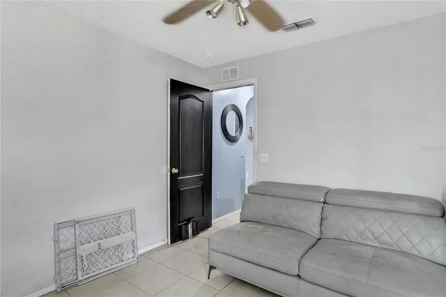 a living room with furniture and a ceiling fan