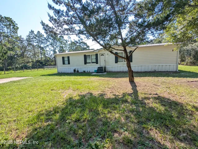 a view of a house with a yard and tree