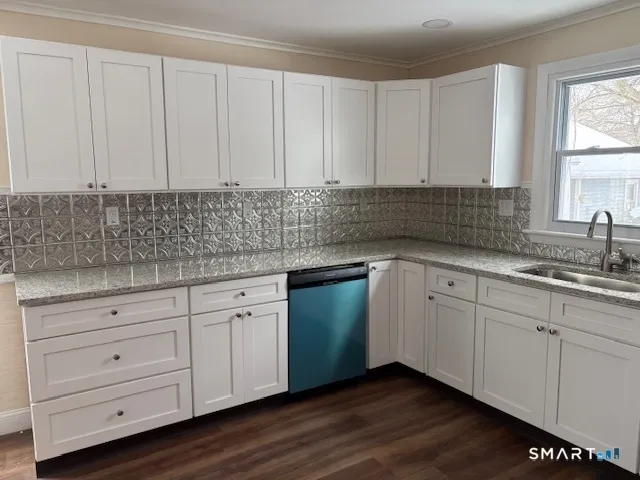 a kitchen with granite countertop white cabinets and sink