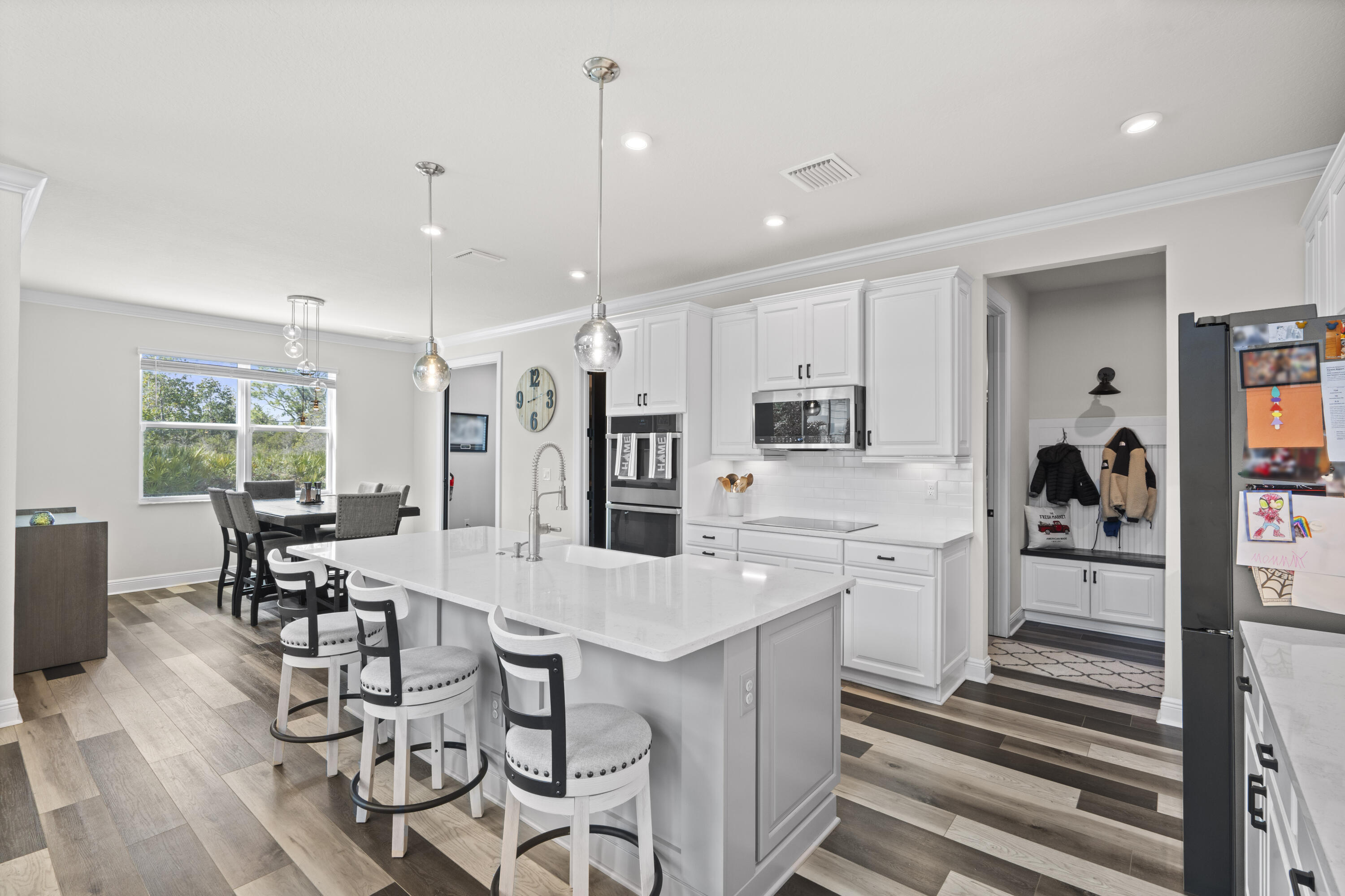684 Southwest Pennfield Terrace Stuart, FL 34997 - Photo 12 of 61 a large kitchen with cabinets chairs and refrigerator