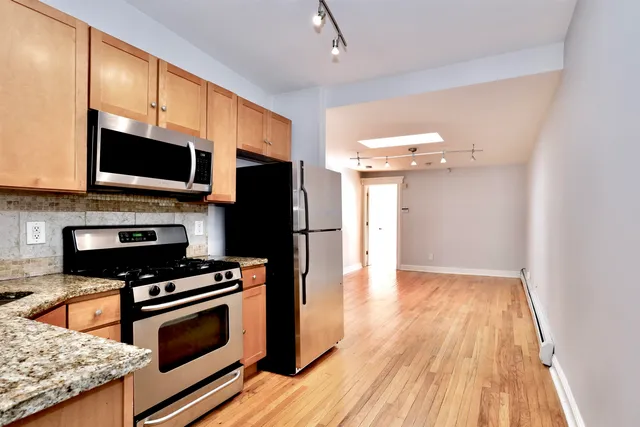 a kitchen with granite countertop a stove cabinets and microwave