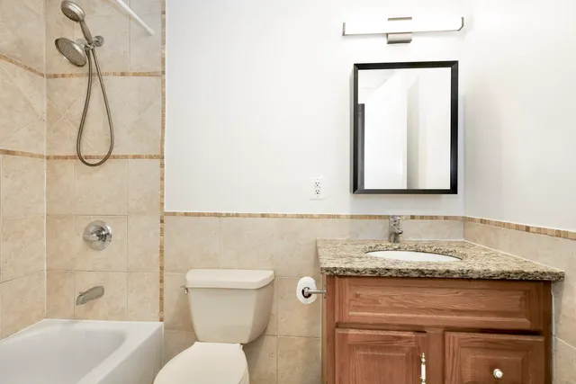 a bathroom with a granite countertop sink toilet and shower