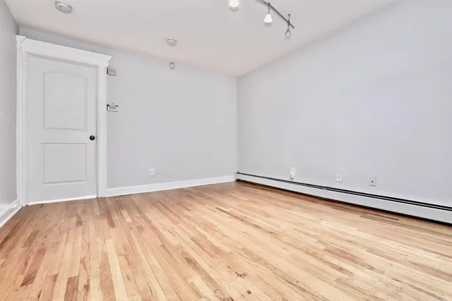 a view of empty room with wooden floor