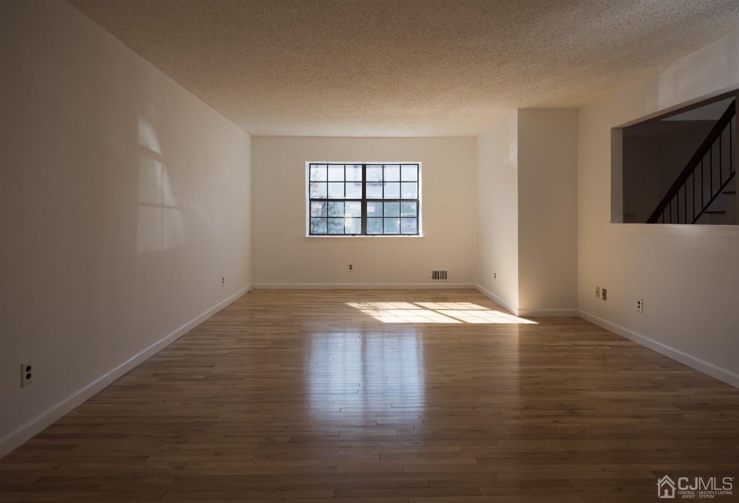 5403 Hana Road Edison, NJ 08817 - Photo 5 of 12 an empty room with wooden floor and window