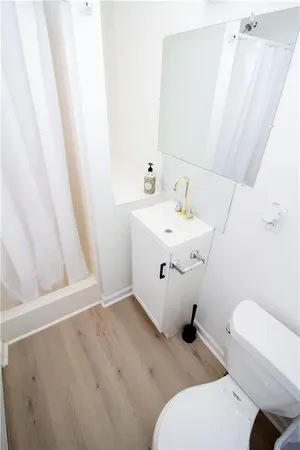 a bathroom with a sink a toilet and mirror