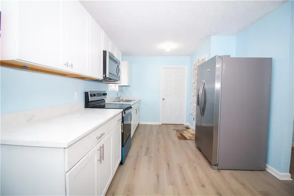a kitchen with stainless steel appliances a refrigerator and a stove top oven
