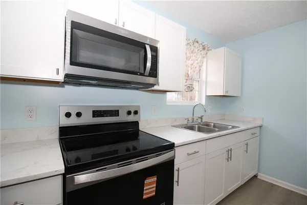 a kitchen with a stove microwave and sink