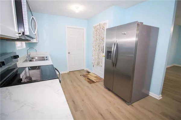 a kitchen with stainless steel appliances granite countertop a refrigerator a stove and a sink