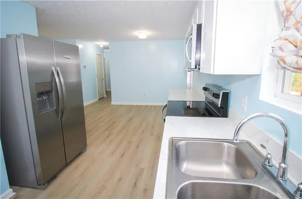 a kitchen with stainless steel appliances a refrigerator sink and microwave