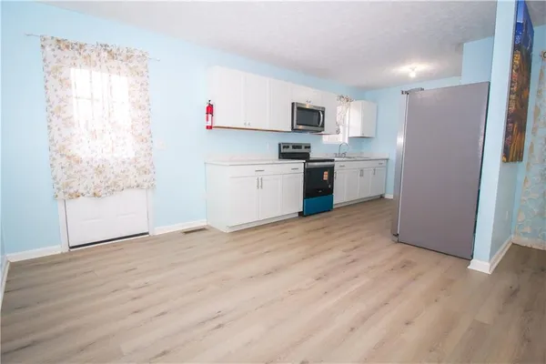 a kitchen with stainless steel appliances a refrigerator sink and microwave