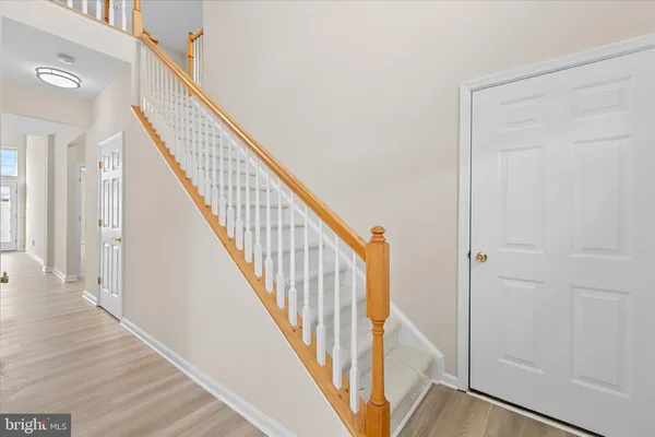 a view of a hallway with wooden floor and staircase