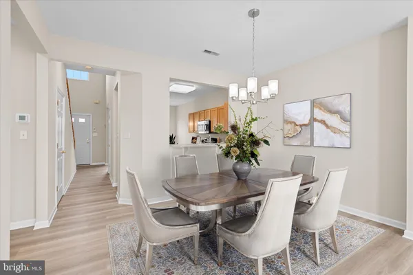 a dining room with furniture a chandelier and wooden floor