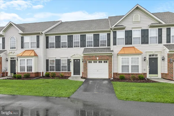 a front view of a house with a yard and potted plants